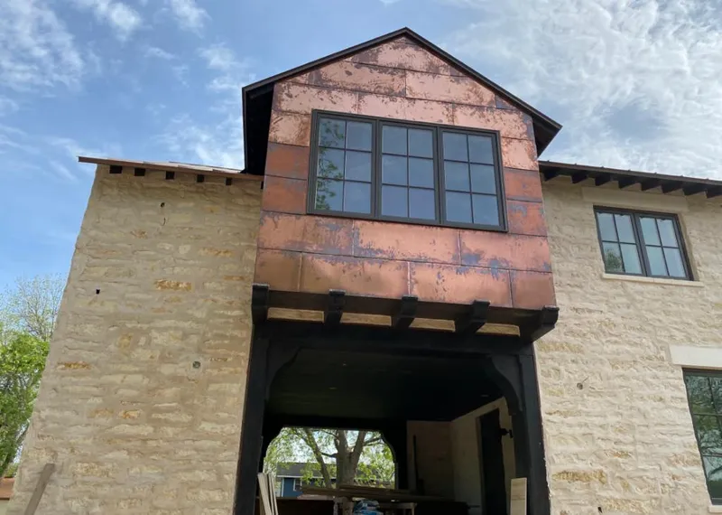 Copper metal panel facade on a stone building for Roof Repair in Denton